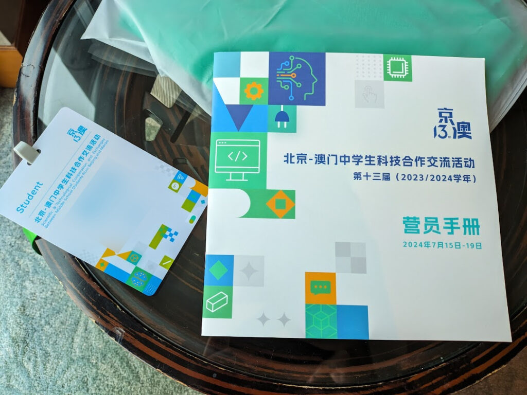 A booklet about the event on a transparent glass table and a badge for participants of the event..